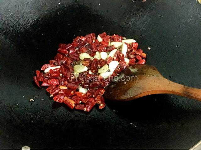 然后加入辣椒和花椒小火慢慢炒香