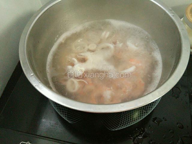 把鱿鱼和虾仁入开水锅焯至变色捞起备用。