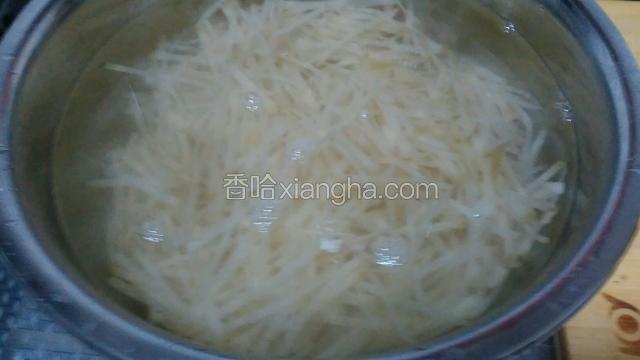 将咸菜切丝后泡入凉水中，期间换两次水