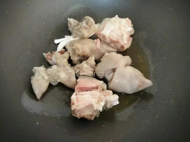 锅中放入植物油烧热，将猪蹄放进去煸炒一分钟左右。