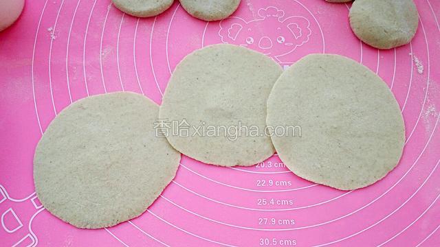 用擀面杖擀成中间厚外圈薄的饼皮。