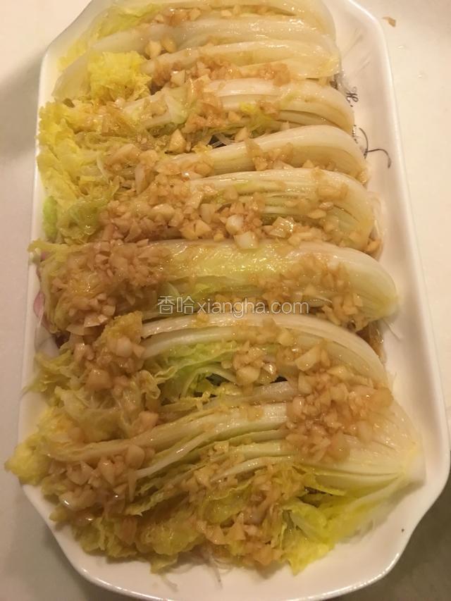用勺子将酱汁均匀淋在娃娃菜上面，加入胡萝卜粒