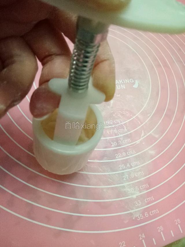 提起模具，慢慢按下压板，推出月饼。