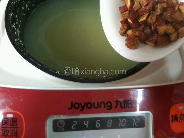 大约二十多分钟之后，电饭煲自动停止，放入去核的红枣丁，继续盖上盖，煮五分钟即可。