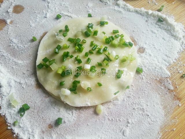 在盖一层饺子皮，抹上一层油，撒点葱花和细盐