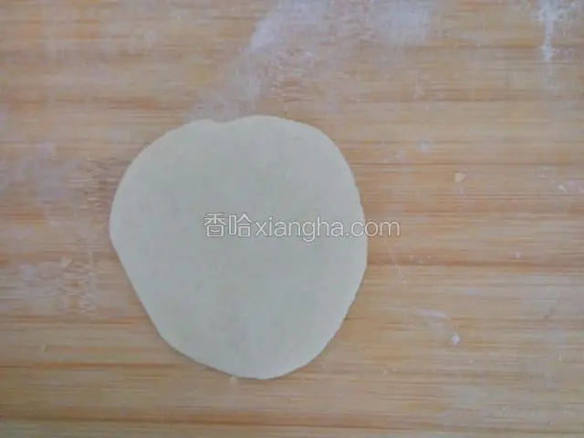 用擀面杖擀成中间厚两边薄的圆片