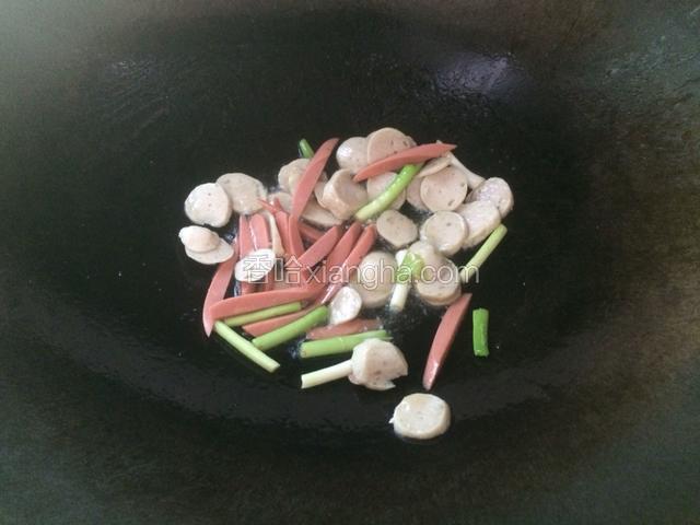 锅里留少许煎好的猪油，倒入肉丸，火腿，蒜苗梗爆炒一下。