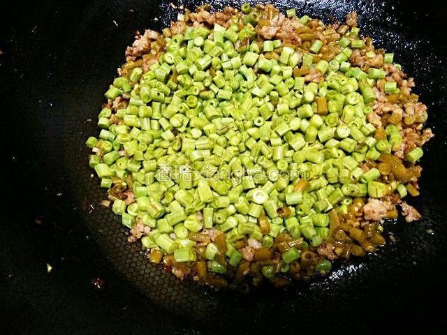 肉沫微焦时放入酸豆角，炒出香味儿时下葱姜和新鲜豆角