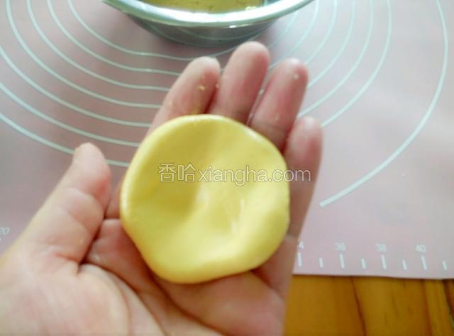 取一小面团，揉圆压成窝状。