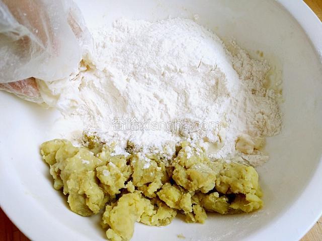 蒸熟的红薯带上一次性手套压成红薯泥，然后放入大碗中，再加入适量的面粉和酵母粉。