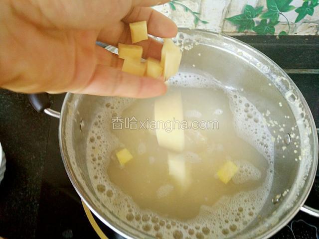 先将小米加水放锅中大火烧开，开锅后再放红薯丁，冰糖块，小火炖煮熬制15分钟。