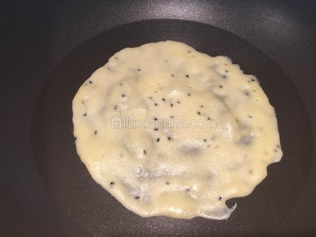 晃动不粘锅，将锅子里面的蛋糊平摊开。
