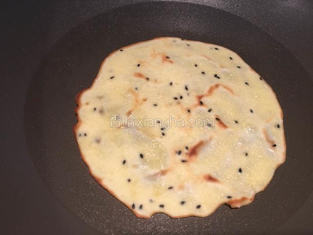 用小火加热，蛋皮边缘变色时，小心的给蛋皮翻面，把另一面用小火煎至有着微黄色。