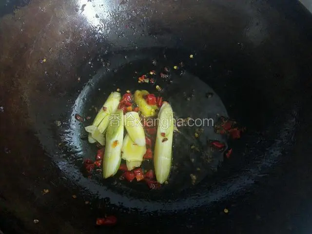 锅中放入比平时炒菜要多的油爆香葱，姜，干辣椒和花椒粒