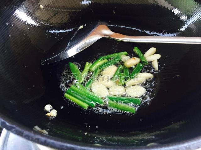 锅里留底油倒入葱段和蒜片炒香。