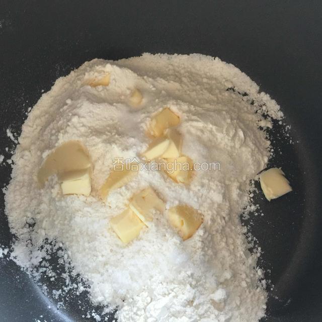 放入切成小丁的黄油，（黄油不要软化）用手指搓的方法，让黄油和粉类混合成粉末状