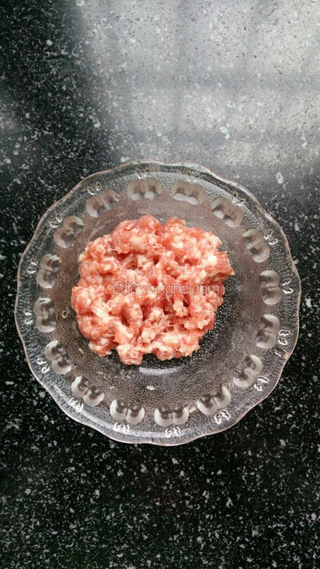 猪肉剁碎，加适量盐和料酒腌制十分钟。