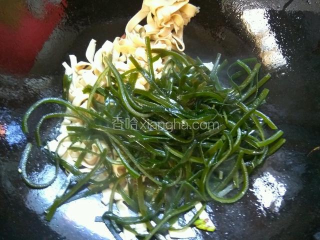 接着放入海带丝翻炒。