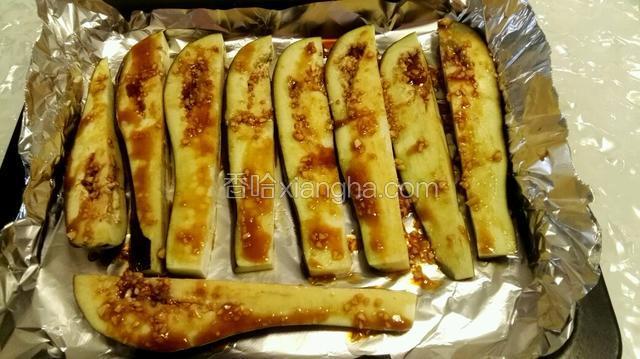 烤盘里铺锡纸，茄子放烤盘里，用勺子浇汁在茄子上，烤箱170℃预热5分钟。