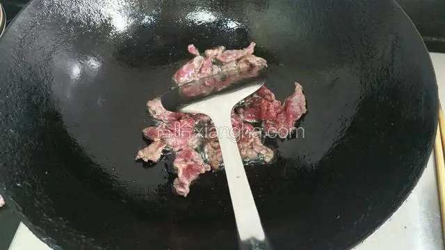 锅里的底油煸炒牛肉1~2分钟