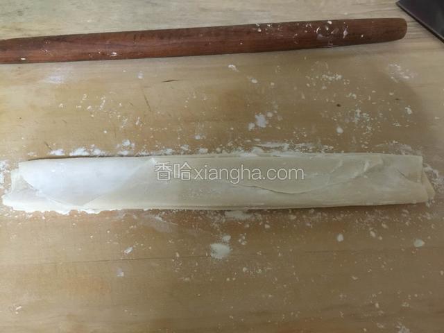 用擀面杖裹紧后反复折叠成长条状，折叠时每层面上抹上适量的淀粉，避免每层面粘连。