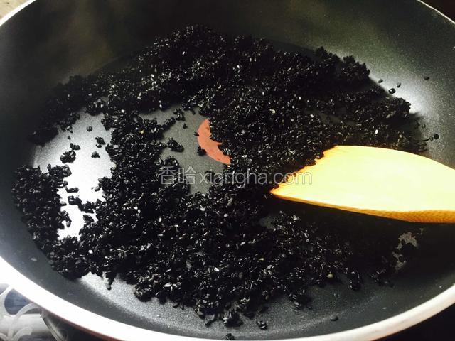 把滤干水分的芝麻放在平底锅中炒干水份。