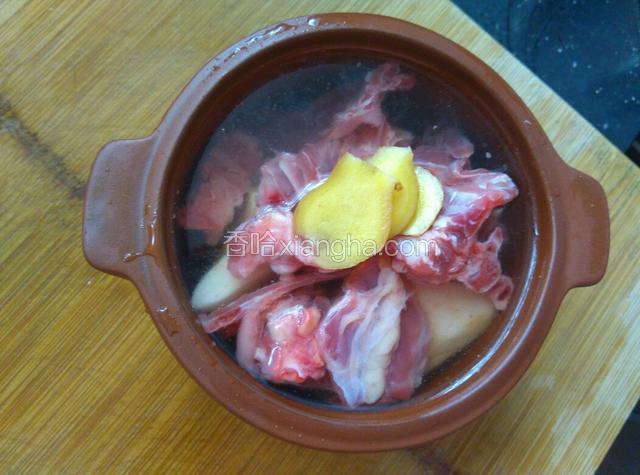 加入鸭骨架、姜片、料酒，加足量水。