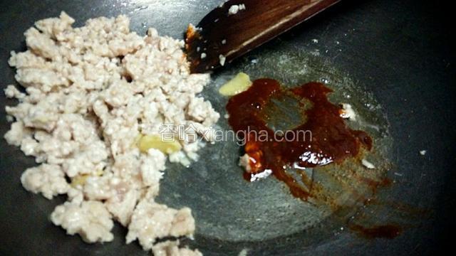 把肉沫推到一边，放入蒜蓉辣酱，炒出红油。