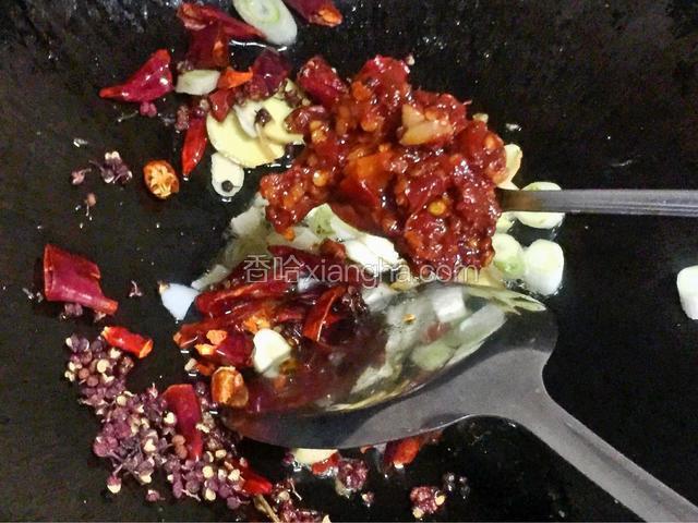 锅里烧油，油六成热，放入盘中佐料，再加入两大勺豆瓣酱（或者两大勺香口鱼调料，或者豆瓣酱、香口鱼调料各一勺，我喜欢各一大勺）