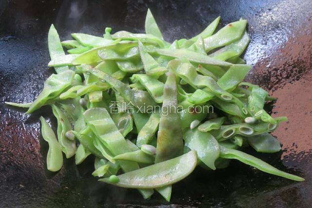 锅里热油放入扁豆丝爆炒。