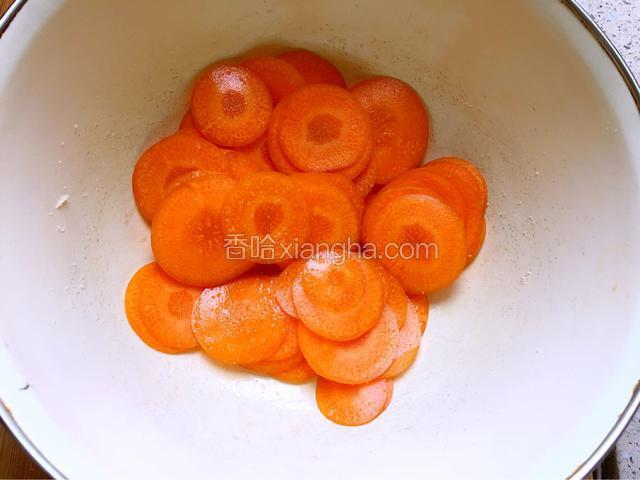 利用蒸山药的时间，将胡萝卜用刨皮器刨成圆形薄片。