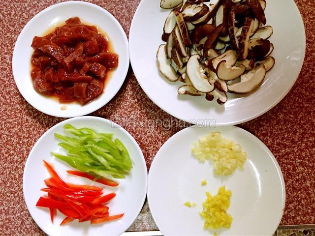 牛肉洗净切条状后加入适量的盐和鸡精、胡椒粉、生抽、料酒拌匀腌制半小时，蘑菇洗净切片，红、青辣椒切丝，蒜、姜切末备用