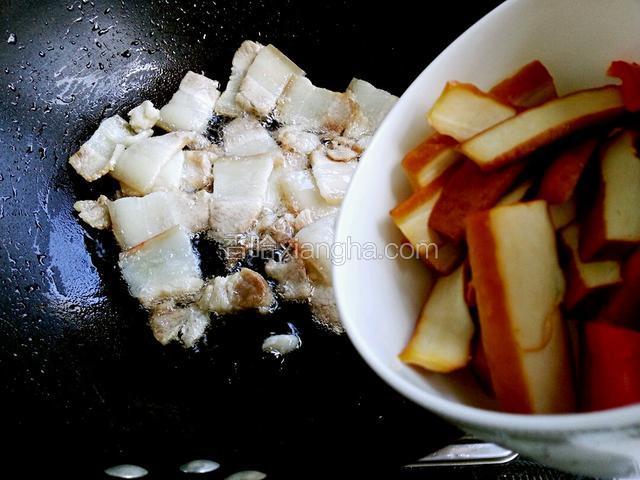 肉片呈透明状，并煸出油时，放入豆腐干和红椒