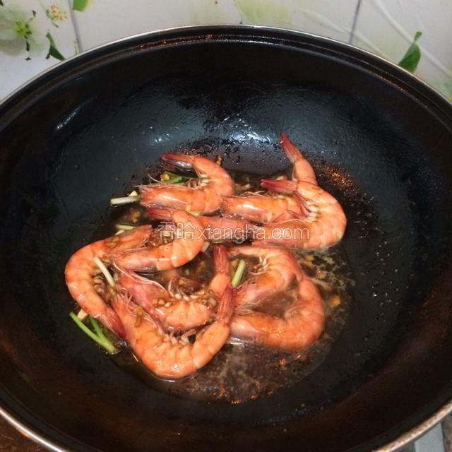 放入虾翻炒至变色，倒入香糟卤烧至2分钟。