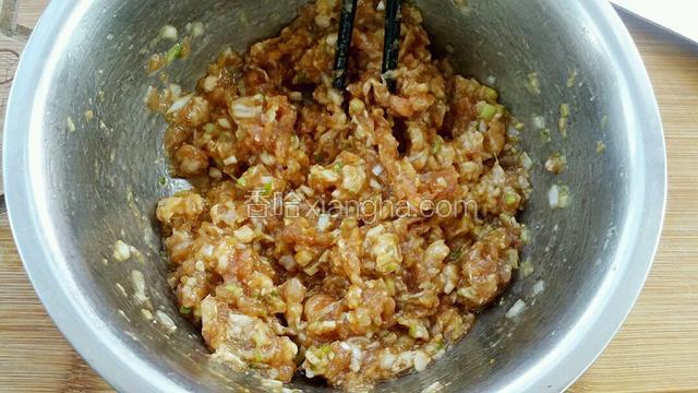 用筷子顺时针一个方向搅拌至肉馅上劲。