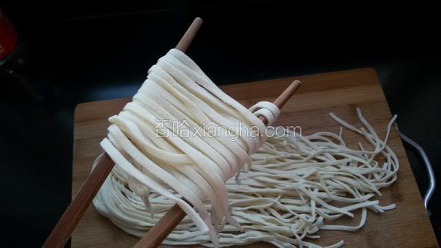 然后把面条绕在筷子上。