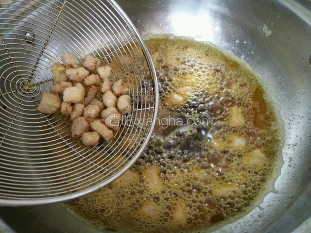 锅里油烧热，肉丁放油里过一遍，大约1分钟捞出，也叫滑油