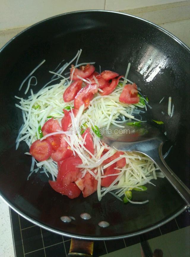 把土豆丝倒进锅里翻炒两下就把西红柿块倒进去一起炒