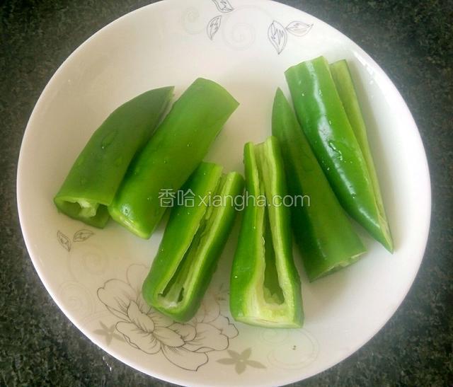 青椒从中间斩两段，每段有一面被切去薄薄的一块，剜去青椒籽，备用。