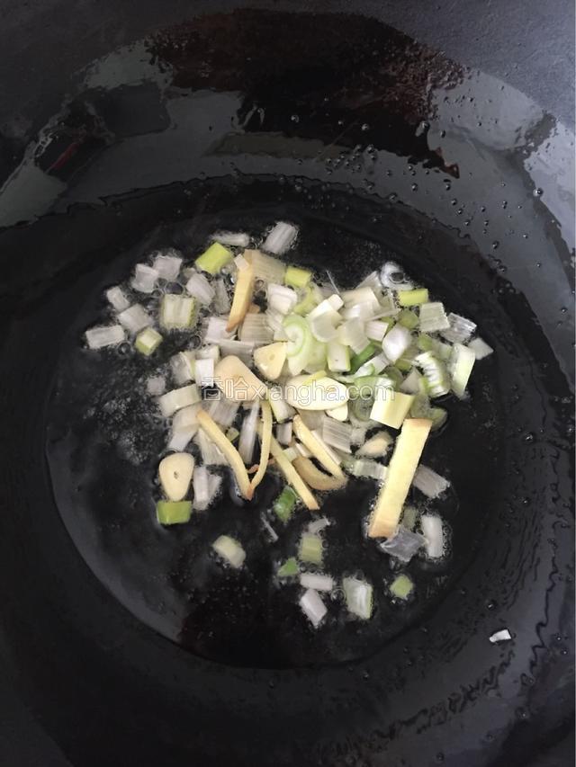 锅中热油爆香葱末和姜片。