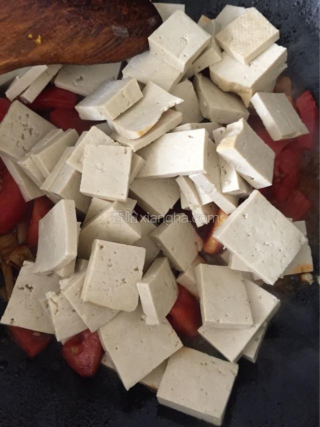 将豆腐放入西红柿中翻炒，放少许酱油，直至豆腐熟透入味，加入适量盐和糖炒均匀。