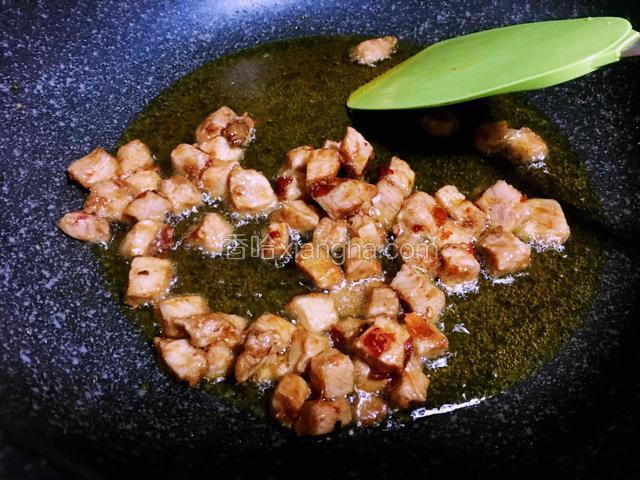 油烧八分热倒入肉丁快速翻炒变色