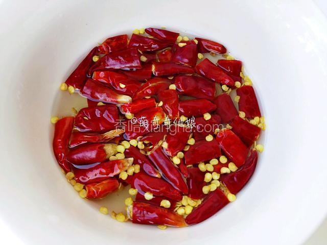 干辣椒剪成段用清水浸泡会儿，再冲洗干净去籽，大蒜去皮拍扁，姜切片，花椒粒一小撮。