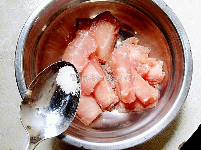 把切好的肉片放碗内，加盐0.5克（进行腌制）