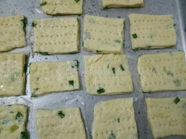然后擀薄切成小块，用叉子扎上排列整齐的小孔。入预热180度的烤箱15分钟即可。