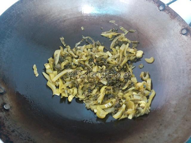 锅里倒油，爆香姜片，再把酸菜倒进炒香