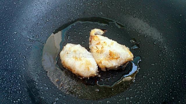 待鳕鱼块两面呈金黄色后，挤入适量的柠檬汁。