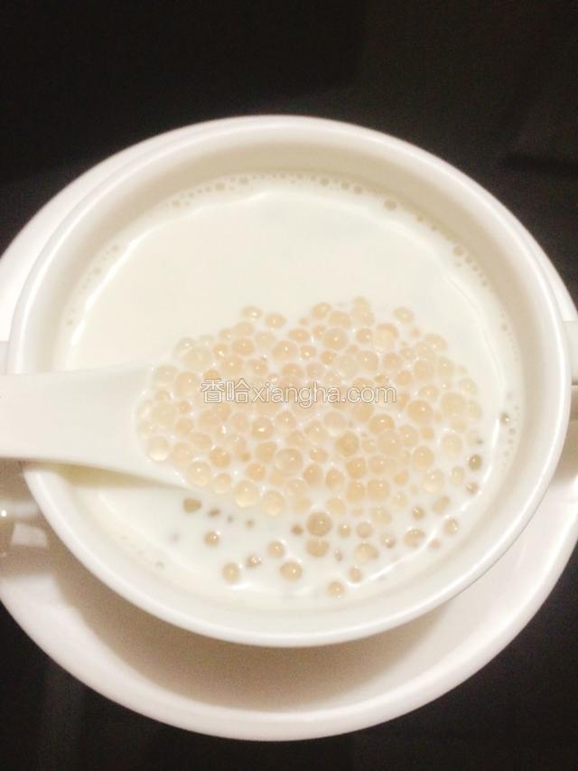碗里倒入椰奶，再把还热的西米倒入椰奶里