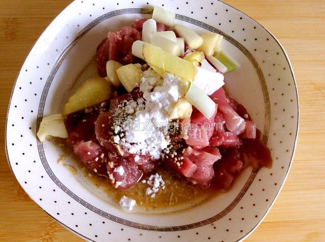 肉片中加葱姜蒜、料酒、淀粉、盐、鸡精，抓拌均匀腌制三十分钟
