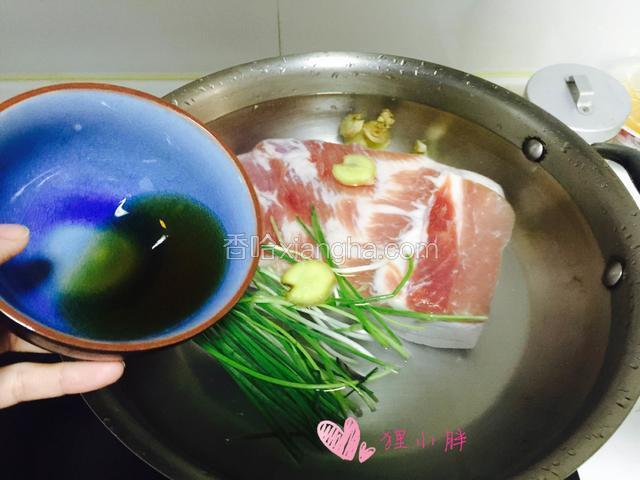 姜和葱分成两份，各取其中一份。姜切片。葱切段。五花肉整块下入锅里，开火煮，加入料酒，葱，姜片，绰水。